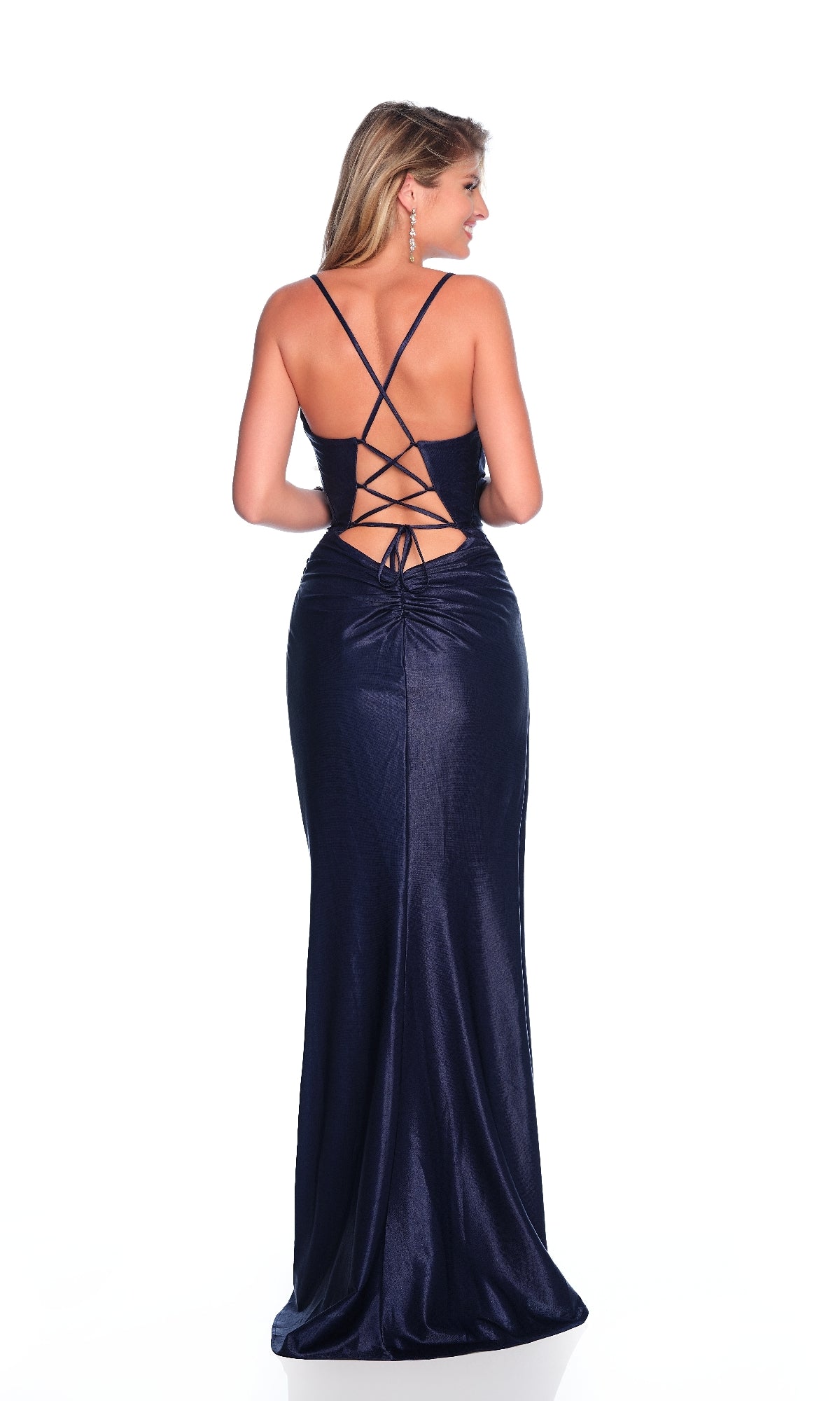 A woman stands facing away on a white background wearing the Dave & Johnny 11953 navy blue prom dress, floor-length and sleeveless with a crisscross lace-up back.